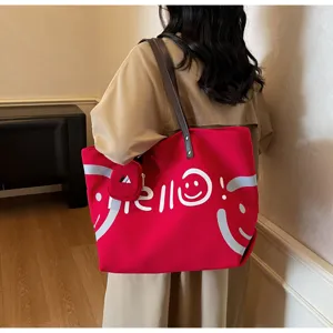Red canvas tote bag detail view, large capacity casual shoulder bag with smiley print.