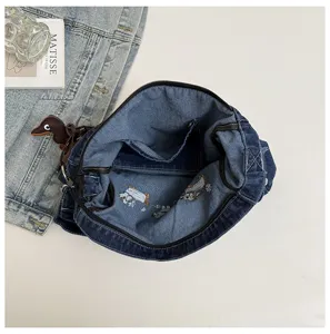 Stylish denim shoulder bag with cute embroidery and dachshund charm for daily commute and school.
