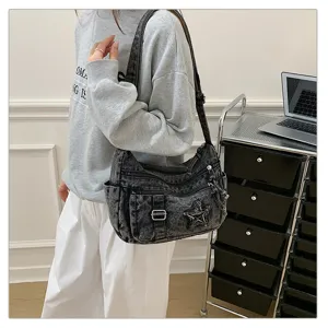 Detalle del bolso de hombro de denim con múltiples bolsillos y parche de estrella.