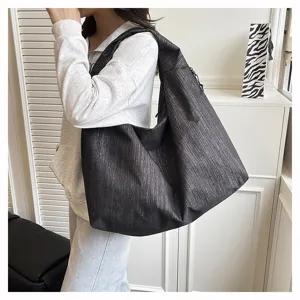 Casual large capacity shoulder tote bag detail shot showing textured shiny black fabric design.