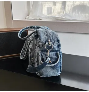 Vintage soft denim tote shoulder bag detail showing multi-pocket design and metal hardware.