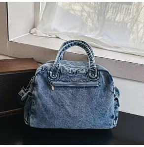 Detailed shot of retro soft denim tote bag, showing distressed fabric and metal zipper.