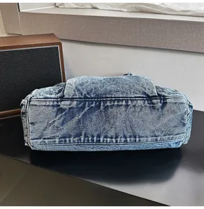 Detail view of the vintage washed denim tote bag showing durable bottom structure and fabric.