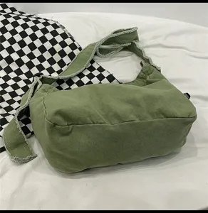 Detailansicht der Canvas Schultertasche mit gewaschenem Stoff, Fransen und verstellbarem Riemen.