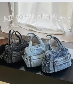 Detail shot of multi-pocket denim tote bags in three wash colors displayed on a dark ledge.
