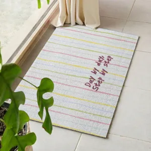 Detailed view of striped non-slip floor mat with inspiring text, perfect for home entryway use.
