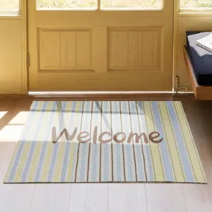 Detail view of striped entry doormat with welcome text in indoor hallway setting.
