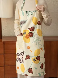 Kitchen apron detail view featuring botanical lemon print and practical front pocket design.