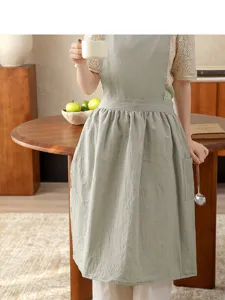 Detail shot of light green cotton linen women kitchen apron with pockets, comfortable and stylish.