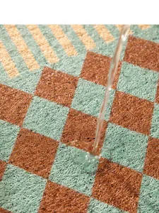 Detail shot of vintage checkerboard silk loop entrance mat, anti-slip foyer floor mat.