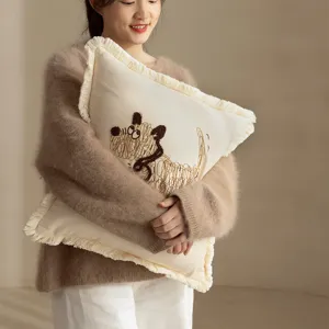 Decorative throw pillow with cute scruffy dog embroidery and chic fringe, soft cream.