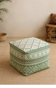 Detailansicht des quadratischen Ethno-Sitzpuffs mit grün-rosa geometrischen Mustern.