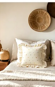 Dettaglio in primo piano del cuscino decorativo con volant in stile crema e ricamo.