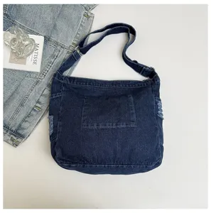 Detail view of the stylish dark blue denim shoulder bag showcasing durable fabric and spacious design.