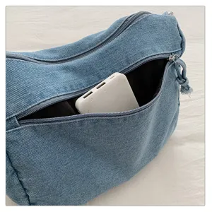 Bolso de hombro de denim vista detallada con bolsillo frontal con cremallera y tela azul.