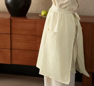 Beige cotton kitchen apron for women, sleeveless cooking smock with pocket and waist tie.