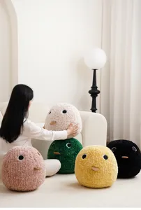 Soft fluffy round creature cushion detail view, showcasing cute eyes and plush texture in room.