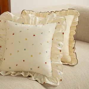 Cuscino decorativo stile crema con ricamo di ciliegie e bordo con volant per divano accogliente.