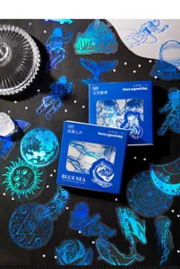 Paketo aftokolliton PET seiras mple thalassa me astronauti kai falaina gia imerologio.