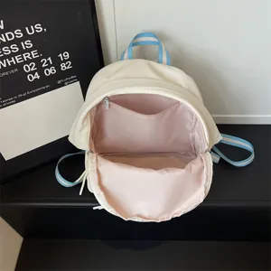 Zaino bianco casual ed elegante con spallacci a righe blu e ampio scomparto interno rosa.