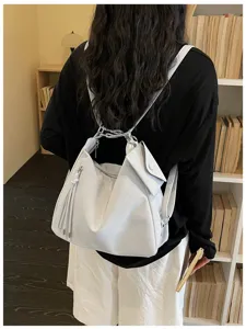 Casual retro slouchy convertible backpack and shoulder bag with small pouch and tassel details.