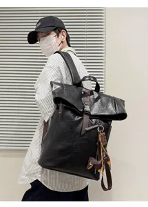 Stylish black roll-top backpack for men, large capacity pu leather casual daypack commute.