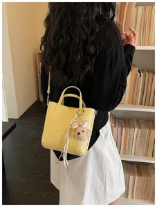 Stylish yellow women crossbody shoulder bag with cute bear pendant, perfect for daily commuting.