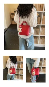 Red shoulder handbag for women with cute bear pendant, stylish casual daily crossbody bag.
