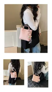 Pink leather shoulder bag detail view with cute bear charm and handbag handle showcasing style.