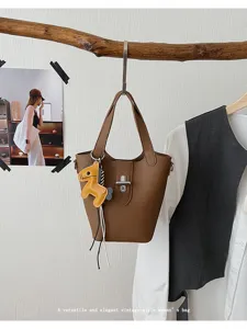 Stijlvolle bruine lederen emmertas voor dames, veelzijdige handtas en schoudertas.