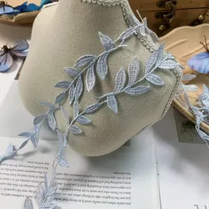 Detalle en primer plano del ribete de encaje bordado azul cielo con motivo de hojas para diy.