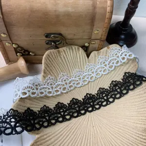 Close-up of black and white hollow embroidered lace trim, perfect for DIY craft and doll clothes.