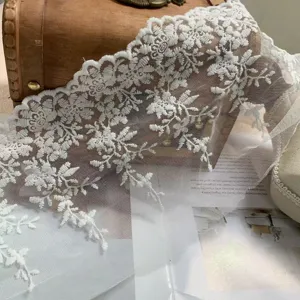 Fijn detail van witte mesh geborduurde kantrand, ideaal voor bruidssluiers en jurkzoomen.