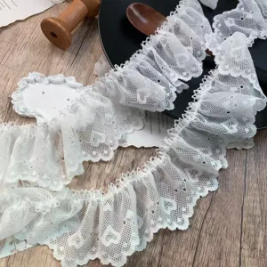 White ruffled lace trim close-up, heart pattern fabric detail for DIY crafts and Lolita apparel.