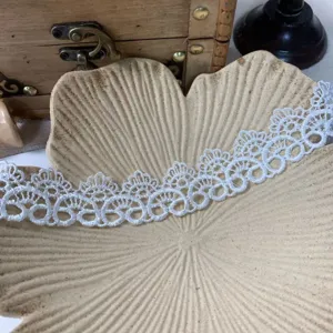 Close up view of white embroidered lace trim for DIY crafts and doll clothes decoration.