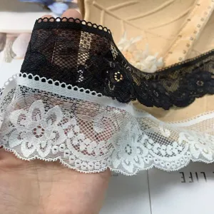 Detailed close-up of 5cm black and white hollow embroidered lace trim for DIY sewing crafts.
