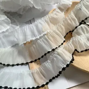 Close-up of 3.8cm white snow yarn lace trim with black dog tooth edge for DIY craft.