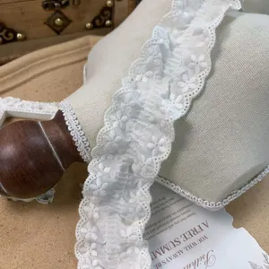 White lace trim detail shot showing the delicate pleated texture and cotton fabric close-up.