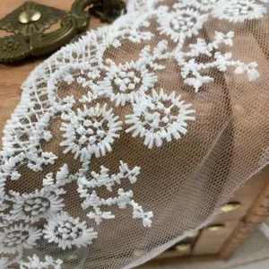 Exquisite white mesh lace trim detail showing delicate floral embroidery and fine texture.