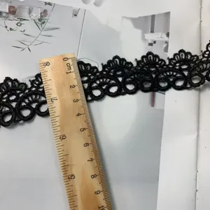 Detailed close-up of black lace embroidery trim, delicate hollow design, perfect for DIY crafts.