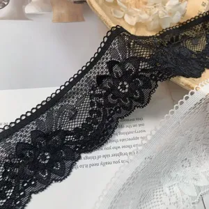 Close-up detail of black and white hollow embroidered lace trim for clothing and DIY crafts.