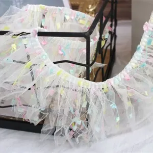 White mesh lace trim detail, 10cm wide decorative ribbon with colorful tassels.