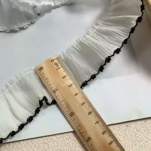 Detailed view of 3.8cm white snow yarn lace trim with black dog tooth edge for DIY craft.