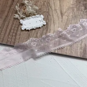 Closeup detail of 5cm pink heart lace trim, delicate embroidery design for DIY.