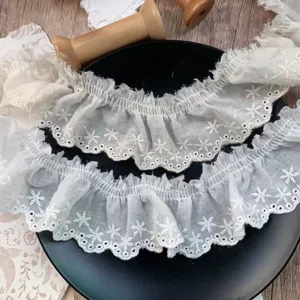 Detailed close-up of 5.5cm wide off-white star embroidered pleated cotton lace trim.
