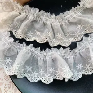 Detailed close-up view of off-white star embroidered pleated cotton lace trim, exquisite texture.