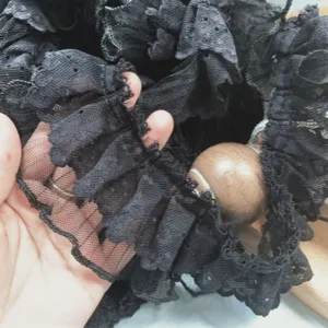 Close-up detail of black double-layer mesh lace ruffle pleated trim for DIY sewing crafts.