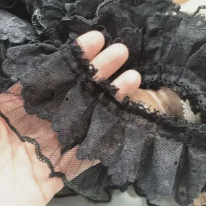 Close-up detail of black double-layer mesh lace ruffle trim, showing delicate texture.
