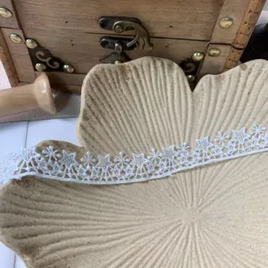 Nahaufnahme einer weißen Polyester-Spitzenborte mit Sternenmuster für Heimwerker.