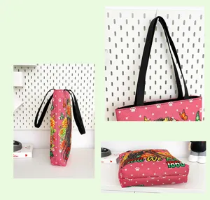 Grand sac cabas en toile rose avec poignées noires, idéal pour un usage quotidien.